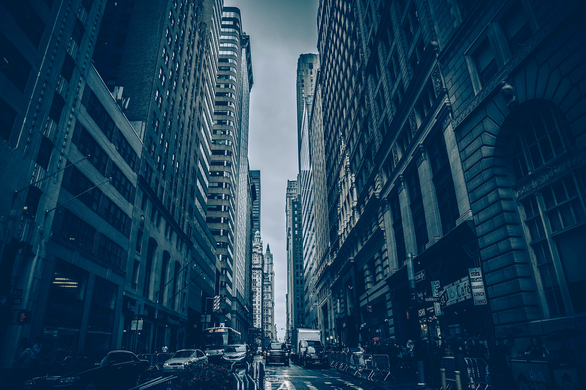 Wet urban street with cars and skyscrapers